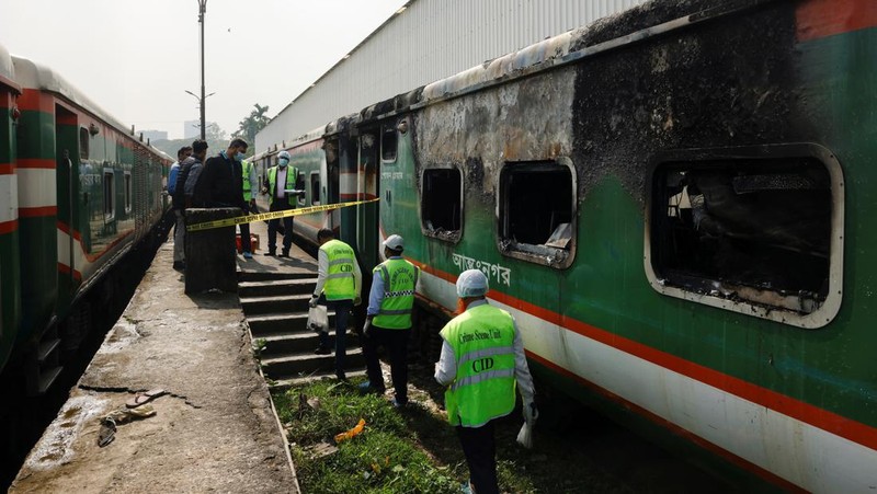 Anggota Unit TKP memeriksa kereta penumpang yang dibakar selama pemogokan nasional yang diserukan oleh Partai Nasionalis Bangladesh, menjelang pemilihan umum, di Dhaka, Bangladesh, 19 Desember 2023. (REUTERS/Mohammad Ponir Hossain)