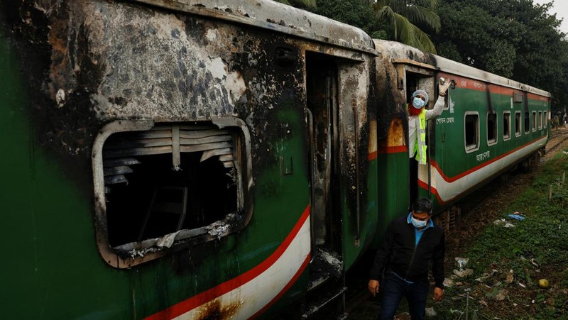 Anggota Unit TKP memeriksa kereta penumpang yang dibakar selama pemogokan nasional yang diserukan oleh Partai Nasionalis Bangladesh, menjelang pemilihan umum, di Dhaka, Bangladesh, 19 Desember 2023. (REUTERS/Mohammad Ponir Hossain)