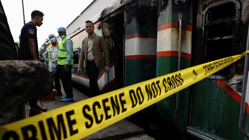 Anggota Unit TKP memeriksa kereta penumpang yang dibakar selama pemogokan nasional yang diserukan oleh Partai Nasionalis Bangladesh, menjelang pemilihan umum, di Dhaka, Bangladesh, 19 Desember 2023. (REUTERS/Mohammad Ponir Hossain)