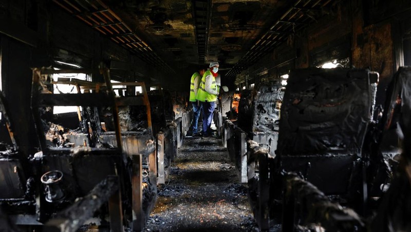 Anggota Unit TKP memeriksa kereta penumpang yang dibakar selama pemogokan nasional yang diserukan oleh Partai Nasionalis Bangladesh, menjelang pemilihan umum, di Dhaka, Bangladesh, 19 Desember 2023. (REUTERS/Mohammad Ponir Hossain)