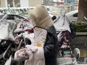 Naik Motor Pakai Selimut Tebal, Cara Unik Orang China Berkendara di Hujan Salju