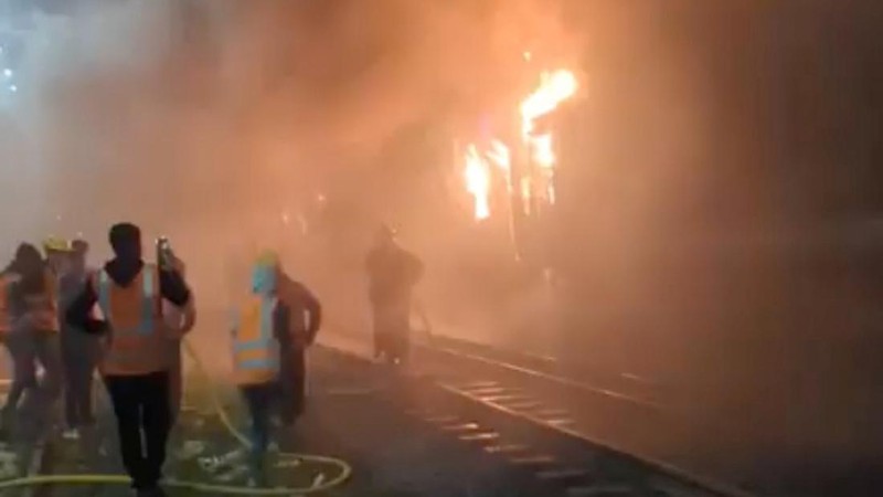 Anggota Unit TKP memeriksa kereta penumpang yang dibakar selama pemogokan nasional yang diserukan oleh Partai Nasionalis Bangladesh, menjelang pemilihan umum, di Dhaka, Bangladesh, 19 Desember 2023. (REUTERS/Mohammad Ponir Hossain)