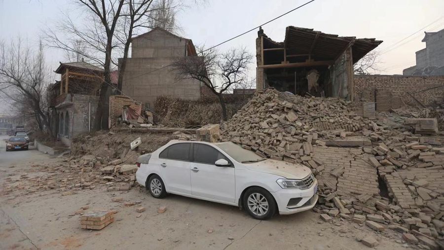 Sebuah kendaraan sebagian tertutup oleh bangunan yang runtuh setelah gempa bumi di desa Dahejia di wilayah Jishishan di provinsi Gansu, Tiongkok barat laut, Selasa, 19 Desember 2023. (Chinatopix via AP)