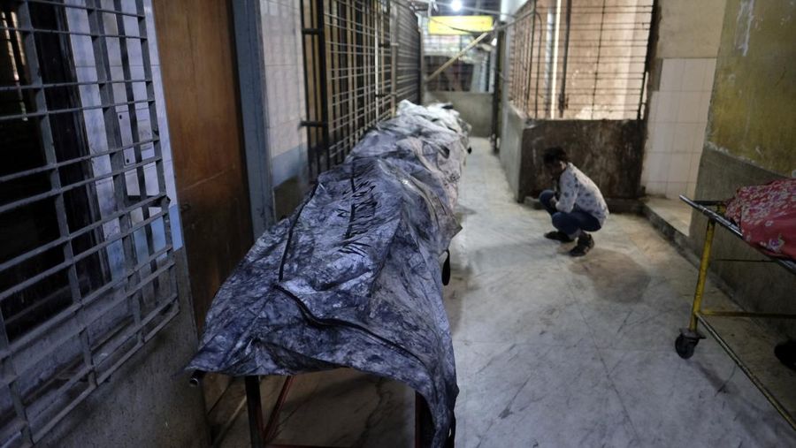 Anggota Unit TKP memeriksa kereta penumpang yang dibakar selama pemogokan nasional yang diserukan oleh Partai Nasionalis Bangladesh, menjelang pemilihan umum, di Dhaka, Bangladesh, 19 Desember 2023. (REUTERS/Mohammad Ponir Hossain)