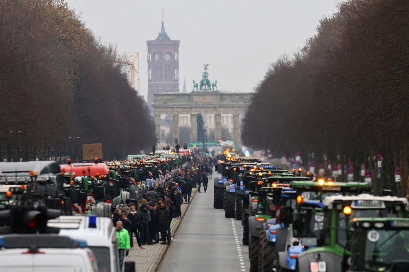 Asosiasi Petani Jerman Bauernverband menolak rencana dan menyerukan demonstrasi besar-besaran di Berlin hari Senin (18/12) waktu setempat. Ribuan petani datang dengan lebih 1.500 traktor mereka, yang memblokir jalan menuju Brandenburger Tor. (REUTERS/Christian Mang) Asosiasi Petani Jerman Bauernverband menolak rencana dan menyerukan demonstrasi besar-besaran di Berlin hari Senin (18/12) waktu setempat. Ribuan petani datang dengan lebih 1.500 traktor mereka, yang memblokir jalan menuju Brandenburger Tor. (REUTERS/Christian Mang)