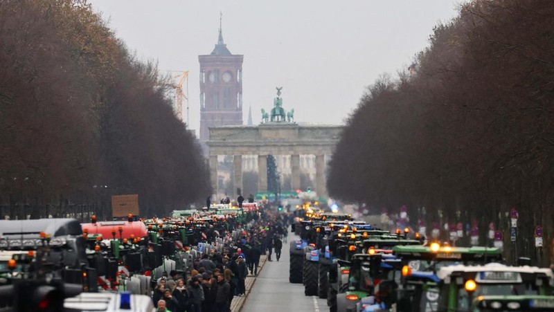 Asosiasi Petani Jerman Bauernverband menolak rencana dan menyerukan demonstrasi besar-besaran di Berlin hari Senin (18/12) waktu setempat. Ribuan petani datang dengan lebih 1.500 traktor mereka, yang memblokir jalan menuju Brandenburger Tor. (REUTERS/Christian Mang)