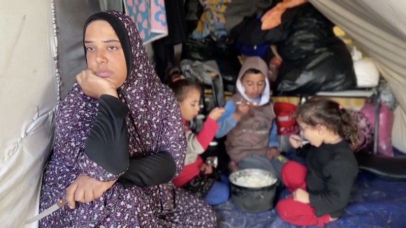 Anak-anak Palestina memegang panci saat mereka mengantri untuk menerima makanan yang dimasak oleh dapur amal, di tengah kekurangan pasokan makanan, saat konflik antara Israel dan Hamas berlanjut, di Rafah di selatan Jalur Gaza 14 Desember 2023. (REUTERS/Saleh Salem)