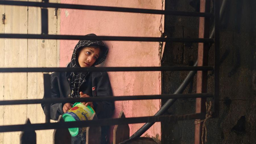 Anak-anak Palestina memegang panci saat mereka mengantri untuk menerima makanan yang dimasak oleh dapur amal, di tengah kekurangan pasokan makanan, saat konflik antara Israel dan Hamas berlanjut, di Rafah di selatan Jalur Gaza 14 Desember 2023. (REUTERS/Saleh Salem)