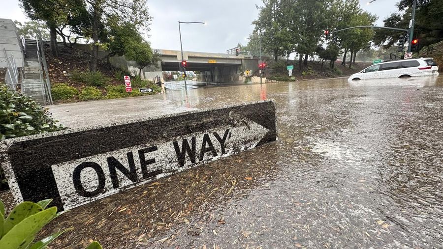 Air banjir mencapai puncak rambu jalan dekat jembatan layang saat hujan turun, Kamis, 21 Desember 2023, di Santa Barbara, California. (AP Photo/Eugene Garcia)