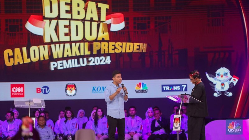Calon Wakil Presiden Nomor Urut 2 Gibran Rakabuming Raka tiba-tiba keluar dari podium dan mendekati Calon Wakil Presiden Nomor Urut 3 Mahfud MD. Gibran menjelaskan soal rasio pajak ke Mahfud MD. (CNBC Indonesia/Faisal Rahman)