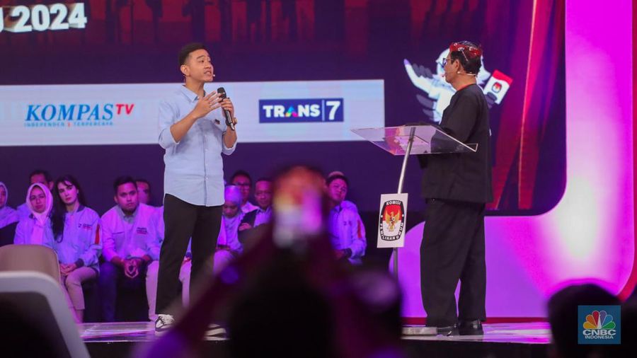 Calon Wakil Presiden Nomor Urut 2 Gibran Rakabuming Raka tiba-tiba keluar dari podium dan mendekati Calon Wakil Presiden Nomor Urut 3 Mahfud MD. Gibran menjelaskan soal rasio pajak ke Mahfud MD. (CNBC Indonesia/Faisal Rahman)
