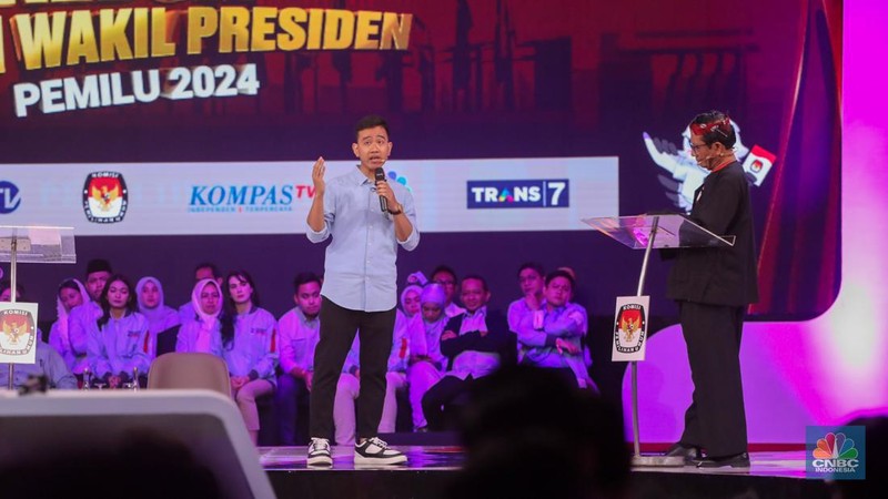Calon Wakil Presiden Nomor Urut 2 Gibran Rakabuming Raka tiba-tiba keluar dari podium dan mendekati Calon Wakil Presiden Nomor Urut 3 Mahfud MD. Gibran menjelaskan soal rasio pajak ke Mahfud MD. (CNBC Indonesia/Faisal Rahman)