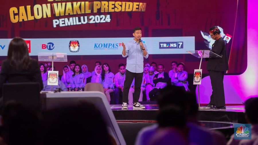 Calon Wakil Presiden Nomor Urut 2 Gibran Rakabuming Raka tiba-tiba keluar dari podium dan mendekati Calon Wakil Presiden Nomor Urut 3 Mahfud MD. Gibran menjelaskan soal rasio pajak ke Mahfud MD. (CNBC Indonesia/Faisal Rahman)