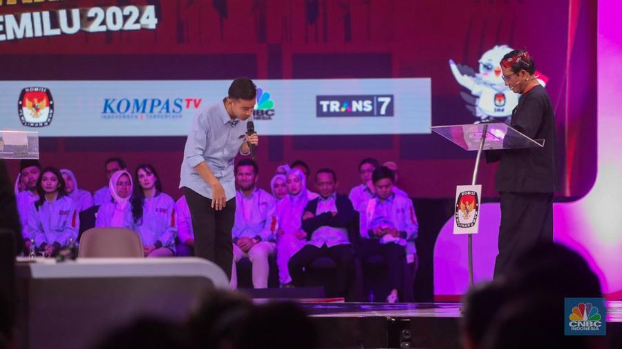 Calon Wakil Presiden Nomor Urut 2 Gibran Rakabuming Raka tiba-tiba keluar dari podium dan mendekati Calon Wakil Presiden Nomor Urut 3 Mahfud MD. Gibran menjelaskan soal rasio pajak ke Mahfud MD. (CNBC Indonesia/Faisal Rahman)