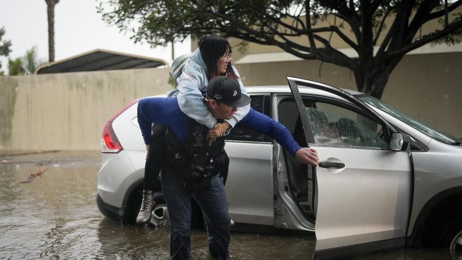 Air banjir mencapai puncak rambu jalan dekat jembatan layang saat hujan turun, Kamis, 21 Desember 2023, di Santa Barbara, California. (AP Photo/Eugene Garcia)
