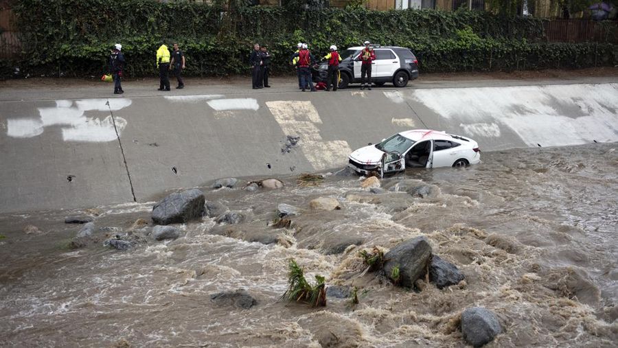 Air banjir mencapai puncak rambu jalan dekat jembatan layang saat hujan turun, Kamis, 21 Desember 2023, di Santa Barbara, California. (AP Photo/Eugene Garcia)