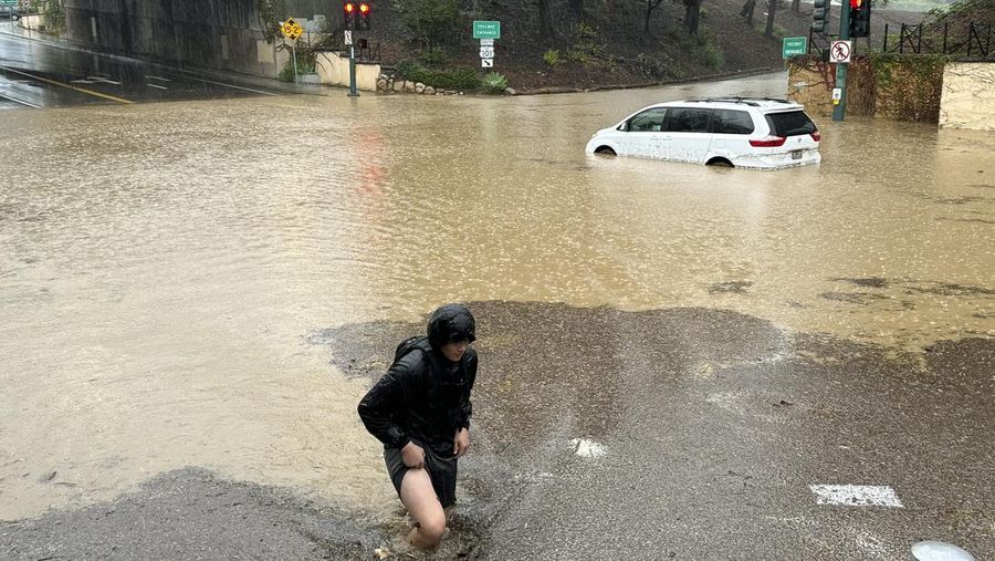 Air banjir mencapai puncak rambu jalan dekat jembatan layang saat hujan turun, Kamis, 21 Desember 2023, di Santa Barbara, California. (AP Photo/Eugene Garcia)