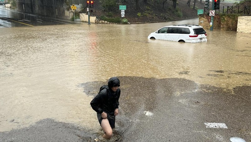 Air banjir mencapai puncak rambu jalan dekat jembatan layang saat hujan turun, Kamis, 21 Desember 2023, di Santa Barbara, California. (AP Photo/Eugene Garcia)