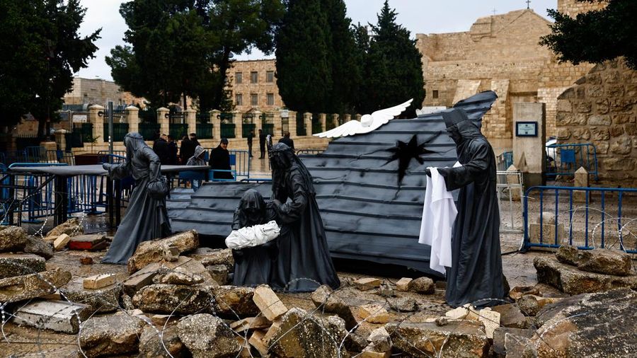 A Christmas installation of a grotto with figures standing amid rubble surrounded by a razor wire, is displayed outside the Church of the Nativity, in support of Gaza, on Manger Square in Bethlehem, in the Israeli-occupied West Bank December 24, 2023. REUTERS/Clodagh Kilcoyne