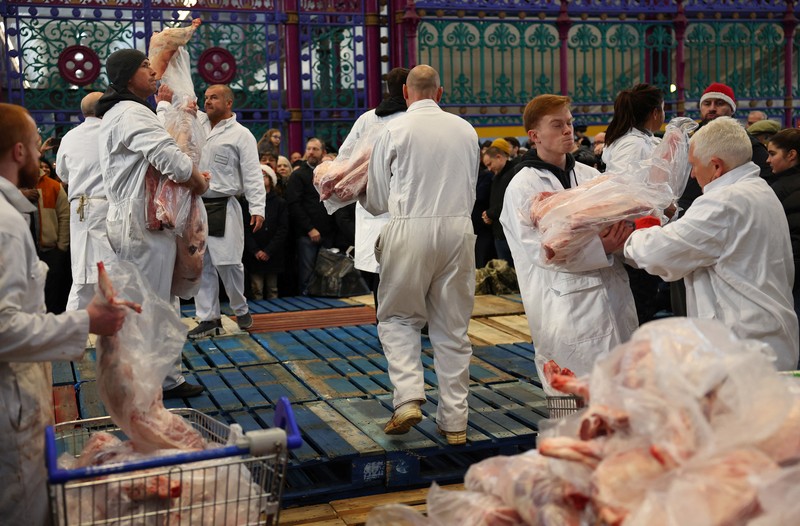 CHRISTMAS-SEASON/BRITAIN-AUCTION A butcher gathers meat cuts before a a pre-Christmas meat auction held by G Lawrence butchers at Smithfield Market in London, Britain, December 23, 2023. REUTERS/Toby Melville