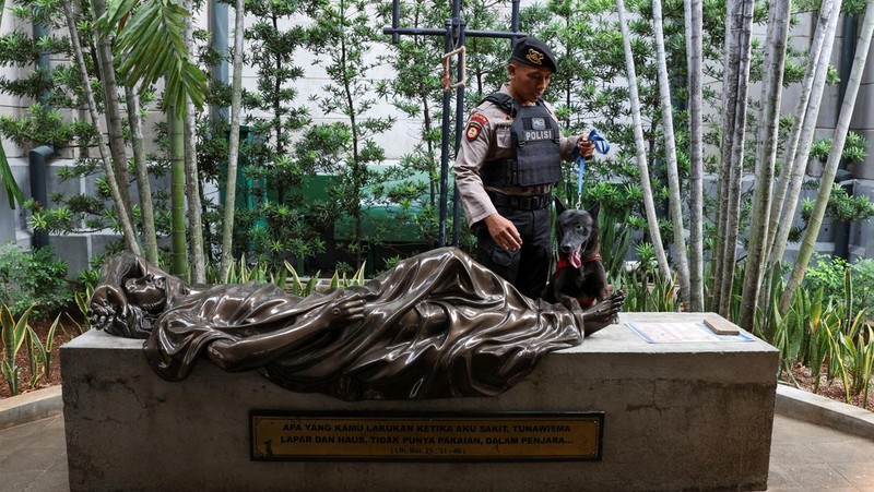 A police officer with a sniffer dog inspects Jakarta Cathedral ahead of the Christmas Mass in Jakarta, Indonesia, December 24, 2023. REUTERS/Ajeng Dinar Ulfiana