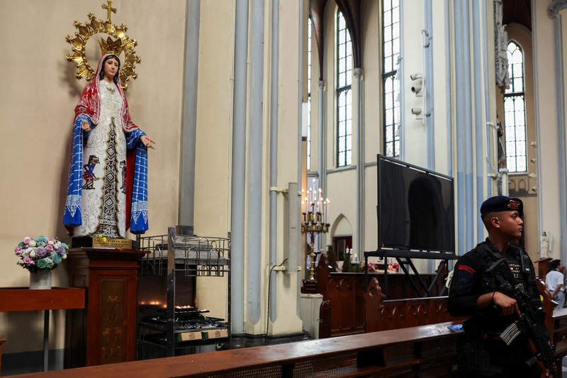 TOTW-CHRISTMAS/ A police officer with a sniffer dog inspects Jakarta Cathedral ahead of the Christmas Mass in Jakarta, Indonesia, December 24, 2023. REUTERS/Ajeng Dinar Ulfiana