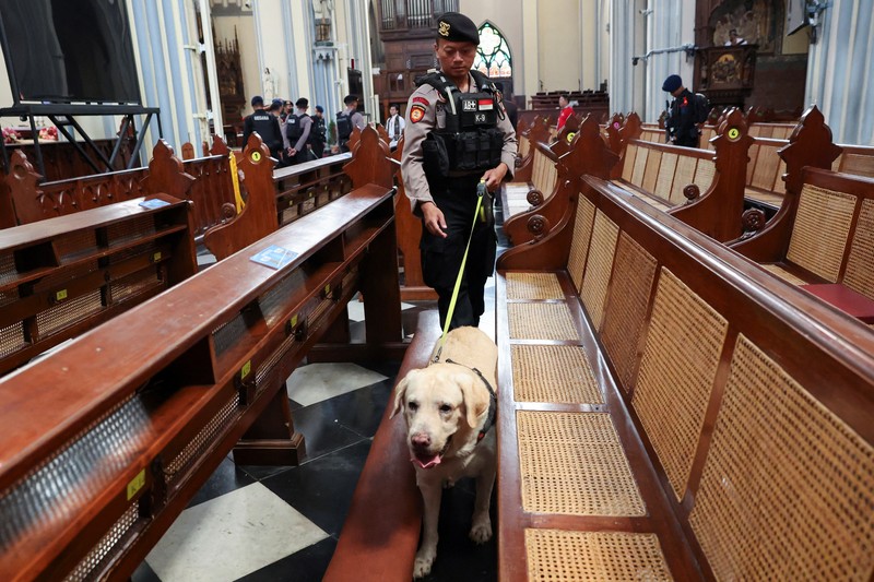 A police officer with a sniffer dog inspects Jakarta Cathedral ahead of the Christmas Mass in Jakarta, Indonesia, December 24, 2023. REUTERS/Ajeng Dinar Ulfiana