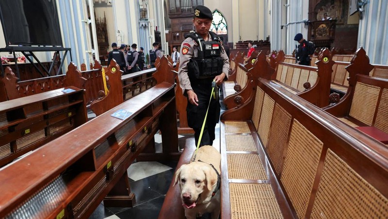 A police officer with a sniffer dog inspects Jakarta Cathedral ahead of the Christmas Mass in Jakarta, Indonesia, December 24, 2023. REUTERS/Ajeng Dinar Ulfiana