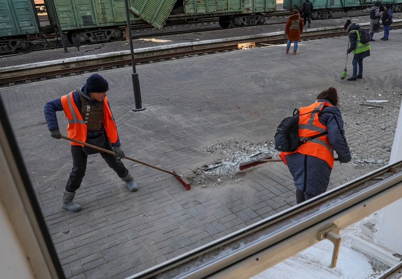 Seorang pekerja membersihkan area di lokasi serangan militer Rusia kemarin, di tengah serangan Rusia ke Ukraina, di stasiun kereta api di Kherson, Ukraina 27 Desember 2023. (REUTERS/Oleksandr Ratushniak)