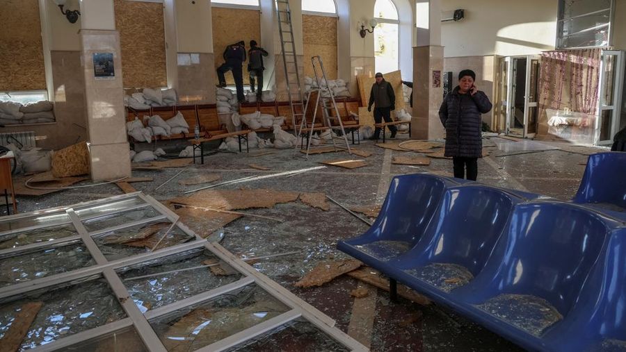 Seorang pekerja membersihkan area di lokasi serangan militer Rusia kemarin, di tengah serangan Rusia ke Ukraina, di stasiun kereta api di Kherson, Ukraina 27 Desember 2023. (REUTERS/Oleksandr Ratushniak)