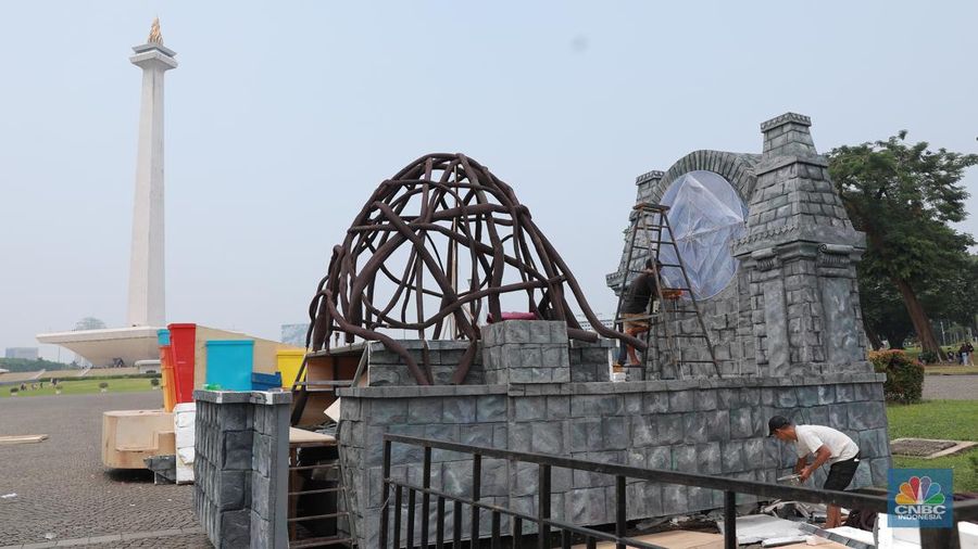 Pekerja seni menyelesaikan dekorasi untuk mobil hias yang akan digunakan untuk Jakarta karnaval sambut tahun baru 2024 di Monas, Jakarta, Rabu, (27/12/2023). (CNBC Indonesia/Muhammad Sabki)