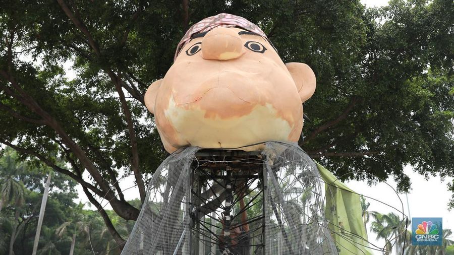 Pekerja seni menyelesaikan dekorasi untuk mobil hias yang akan digunakan untuk Jakarta karnaval sambut tahun baru 2024 di Monas, Jakarta, Rabu, (27/12/2023). (CNBC Indonesia/Muhammad Sabki)