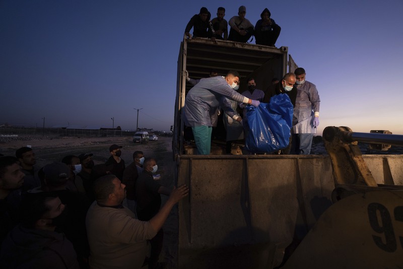 Petugas medis membongkar jenazah warga Palestina yang tewas dalam pertempuran dengan Israel dan diserahkan oleh militer Israel saat pemakaman massal di Rafah, Jalur Gaza, Selasa, 26 Desember 2023. Petugas medis membongkar jenazah warga Palestina yang tewas dalam pertempuran dengan Israel dan diserahkan oleh militer Israel saat pemakaman massal di Rafah, Jalur Gaza, Selasa, 26 Desember 2023. (AP Photo/Fatima Shbair)