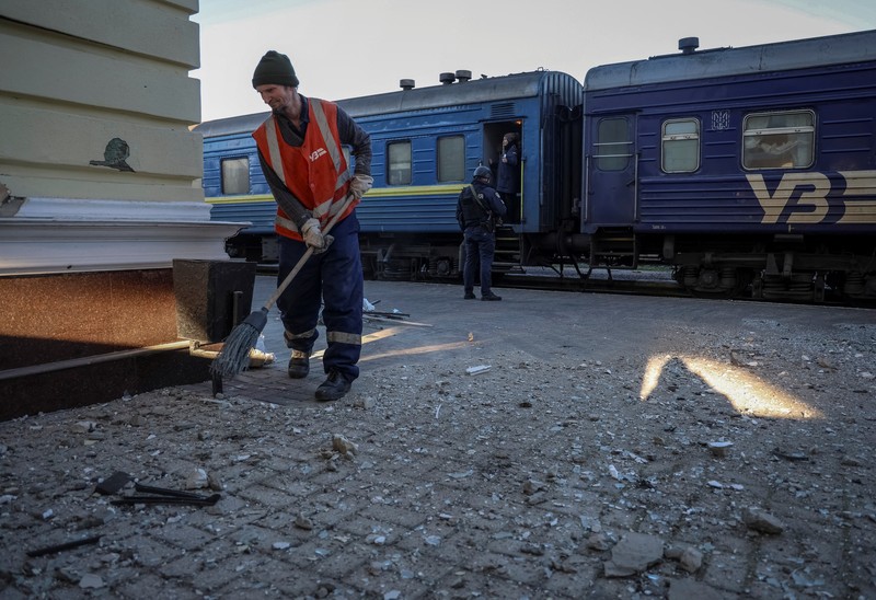 Seorang pekerja membersihkan area di lokasi serangan militer Rusia kemarin, di tengah serangan Rusia ke Ukraina, di stasiun kereta api di Kherson, Ukraina 27 Desember 2023. (REUTERS/Oleksandr Ratushniak)