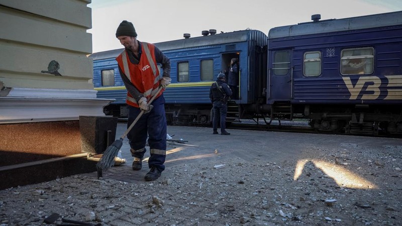 Seorang pekerja membersihkan area di lokasi serangan militer Rusia kemarin, di tengah serangan Rusia ke Ukraina, di stasiun kereta api di Kherson, Ukraina 27 Desember 2023. (REUTERS/Oleksandr Ratushniak)