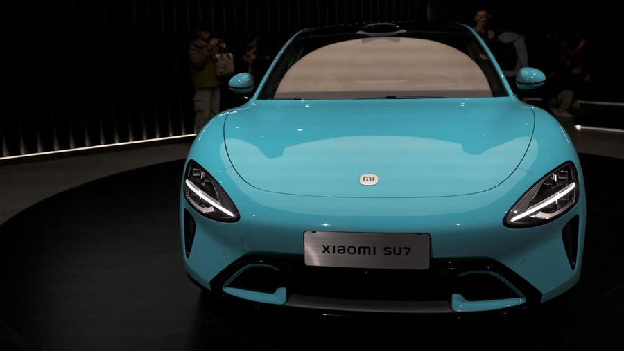 Pengunjung memfilmkan kendaraan listrik pertama Xiaomi, SU7, yang ditampilkan di sebuah acara di Beijing, Cina 28 Desember 2023. (REUTERS/Florence Lo)