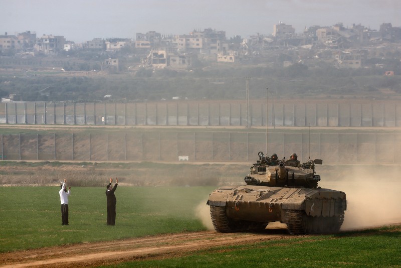 Pria Yahudi ultra-Ortodoks memberi isyarat saat tank Israel melakukan manuver di dekat perbatasan Israel-Gaza, di tengah konflik yang sedang berlangsung antara Israel dan kelompok Islam Palestina Hamas, di Israel selatan, 27 Desember 2023. Pria Yahudi ultra-Ortodoks memberi isyarat saat tank Israel melakukan manuver di dekat perbatasan Israel-Gaza, di tengah konflik yang sedang berlangsung antara Israel dan kelompok Islam Palestina Hamas, di Israel selatan, 27 Desember 2023. (REUTERS/Amir Cohen)