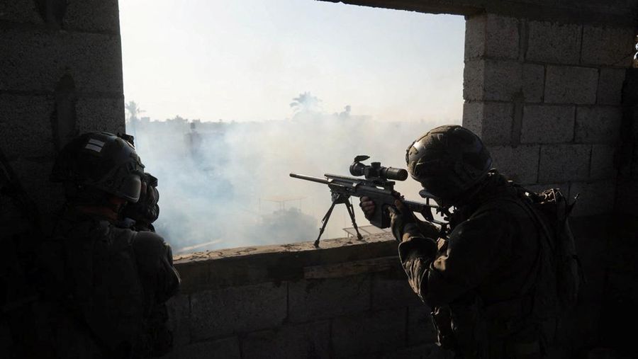 Pria Yahudi ultra-Ortodoks memberi isyarat saat tank Israel melakukan manuver di dekat perbatasan Israel-Gaza, di tengah konflik yang sedang berlangsung antara Israel dan kelompok Islam Palestina Hamas, di Israel selatan, 27 Desember 2023. (REUTERS/Amir Cohen)