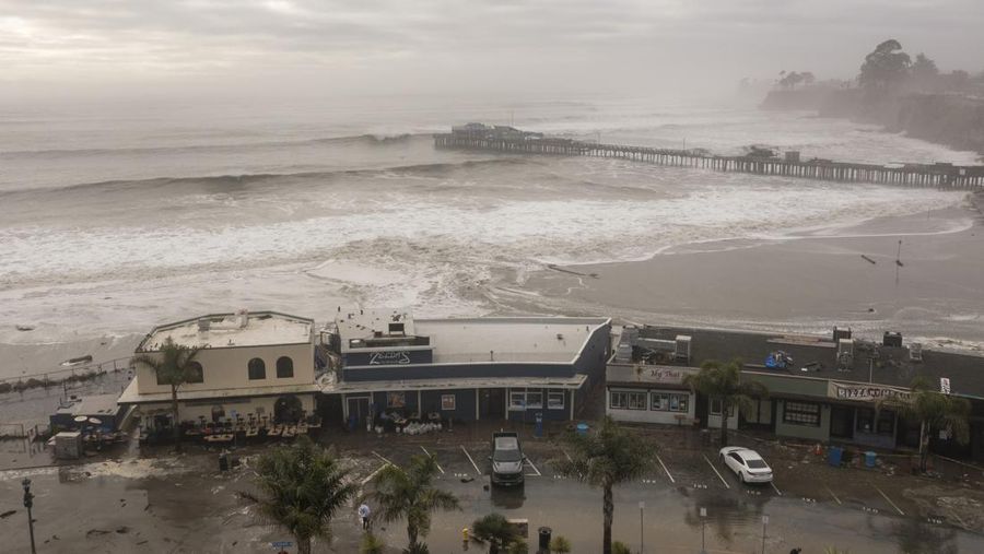 Orang-orang menyaksikan ombak di dekat Dermaga Kota Pacifica di Pacifica, California, Kamis, 28 Desember 2023. Ombak yang kuat bergulung ke pantai-pantai di Pantai Barat dan Hawaii ketika gelombang besar yang dihasilkan oleh badai Samudra Pasifik mendorong menuju garis pantai. (Stephen Lam/San Francisco Chronicle via AP)