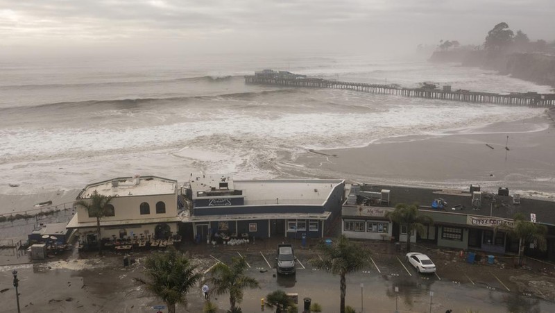 Orang-orang menyaksikan ombak di dekat Dermaga Kota Pacifica di Pacifica, California, Kamis, 28 Desember 2023. Ombak yang kuat bergulung ke pantai-pantai di Pantai Barat dan Hawaii ketika gelombang besar yang dihasilkan oleh badai Samudra Pasifik mendorong menuju garis pantai. (Stephen Lam/San Francisco Chronicle via AP)
