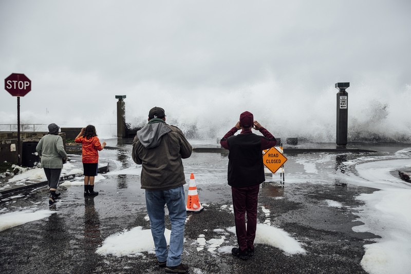 Orang-orang menyaksikan ombak di dekat Dermaga Kota Pacifica di Pacifica, California, Kamis, 28 Desember 2023. Ombak yang kuat bergulung ke pantai-pantai di Pantai Barat dan Hawaii ketika gelombang besar yang dihasilkan oleh badai Samudra Pasifik mendorong menuju garis pantai. (Stephen Lam/San Francisco Chronicle via AP)