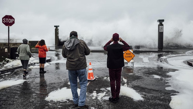 Orang-orang menyaksikan ombak di dekat Dermaga Kota Pacifica di Pacifica, California, Kamis, 28 Desember 2023. Ombak yang kuat bergulung ke pantai-pantai di Pantai Barat dan Hawaii ketika gelombang besar yang dihasilkan oleh badai Samudra Pasifik mendorong menuju garis pantai. (Stephen Lam/San Francisco Chronicle via AP)