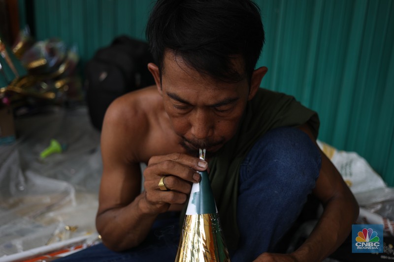 Pedagang meyelesaikan pembuatan trompet di kawasan Jalan Pintu Besar Selatan, Jakarta, Jumat (29/12/2023). Pedagang meyelesaikan pembuatan trompet di kawasan Jalan Pintu Besar Selatan, Jakarta, Jumat (29/12/2023). (CNBC Indonesia/Tri Susilo)
