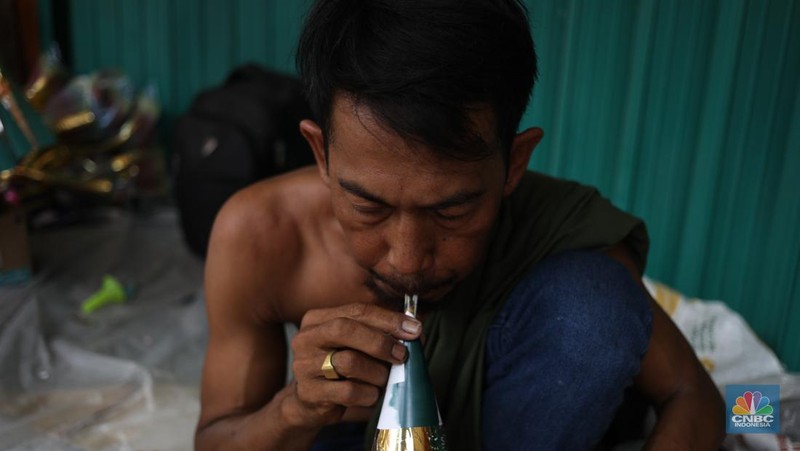 Pedagang meyelesaikan pembuatan trompet di kawasan Jalan Pintu Besar Selatan, Jakarta, Jumat (29/12/2023). (CNBC Indonesia/Tri Susilo)