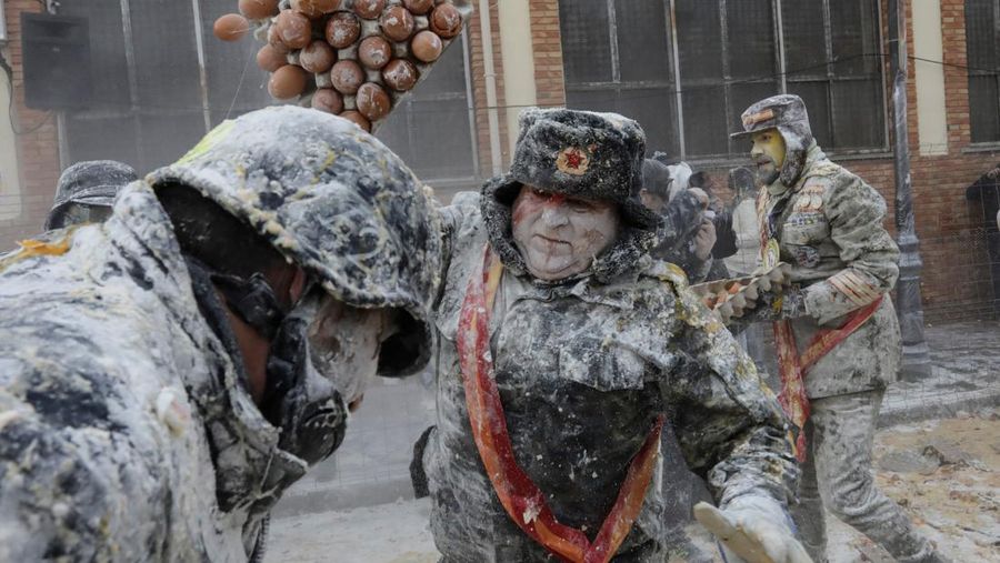 Orang-orang yang bersuka ria berebut tepung dan telur selama festival tradisional 