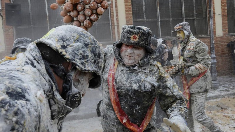 Orang-orang yang bersuka ria berebut tepung dan telur selama festival tradisional 