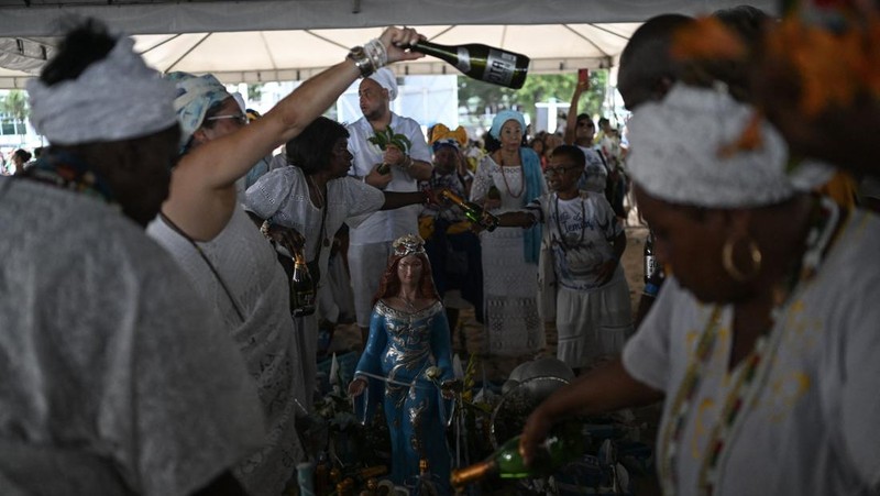 Seorang penganut agama Afro-Brasil memberikan penghormatan kepada Yemanja, dewi laut, dalam perayaan tradisional Malam Tahun Baru di Pantai Copacabana di Rio de Janeiro, Brasil, 29 Desember 2023. (REUTERS/Pilar Olivares)