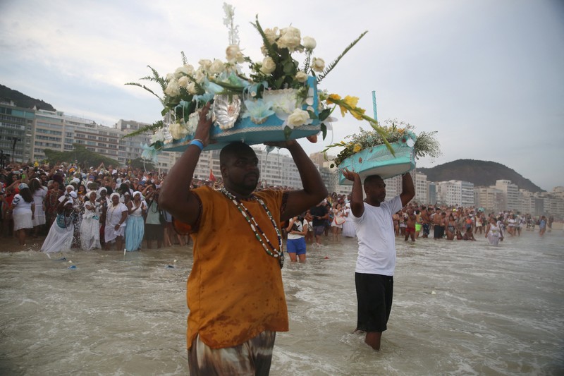 Seorang penganut agama Afro-Brasil memberikan penghormatan kepada Yemanja, dewi laut, dalam perayaan tradisional Malam Tahun Baru di Pantai Copacabana di Rio de Janeiro, Brasil, 29 Desember 2023. (REUTERS/Pilar Olivares)