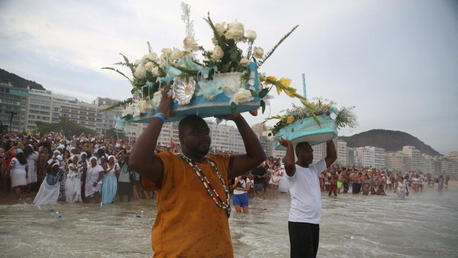 Seorang penganut agama Afro-Brasil memberikan penghormatan kepada Yemanja, dewi laut, dalam perayaan tradisional Malam Tahun Baru di Pantai Copacabana di Rio de Janeiro, Brasil, 29 Desember 2023. (REUTERS/Pilar Olivares)