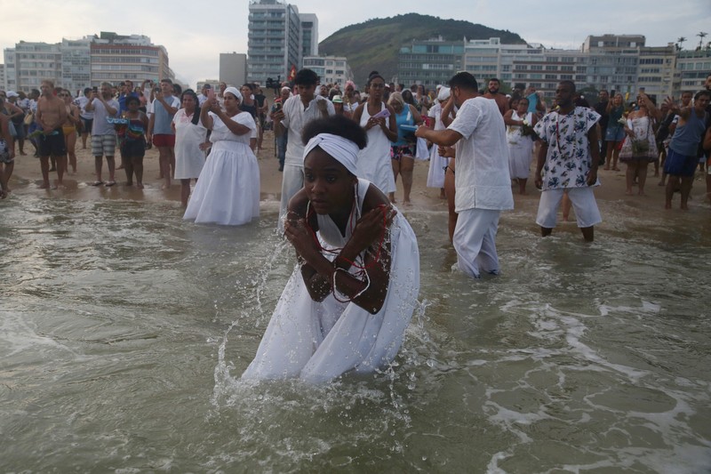 Seorang penganut agama Afro-Brasil memberikan penghormatan kepada Yemanja, dewi laut, dalam perayaan tradisional Malam Tahun Baru di Pantai Copacabana di Rio de Janeiro, Brasil, 29 Desember 2023. (REUTERS/Pilar Olivares)